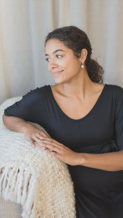 Load image into Gallery viewer, Woman wearing womens hospital gown, patient in cotton wrap dress sitting and leaning over a sofa