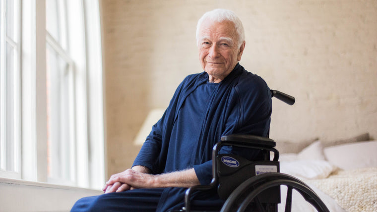 Load image into Gallery viewer, The Arkeras hospital patient gown has been tested for wheelchair use and the comfort stands the gait belt test. Our model enjoys the adaptability of our examination gown for most patient uses. Hospital gown for men can be styled in trendy ways to align with your patient's needs and style.