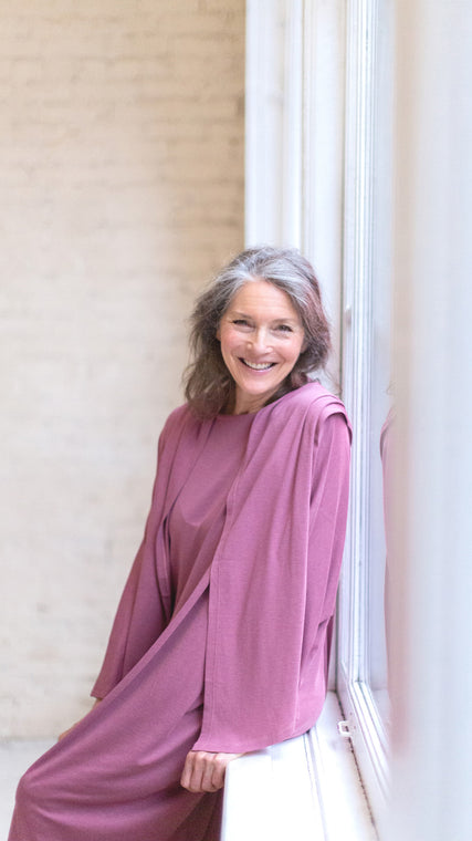 Load image into Gallery viewer, Modeling the Arkeras Classic gown in peony, each organic cotton and Tencel Lyocell fiber breathes happiness into your healthcare journey. Our model's vibrant personality sings for health of body, mind, and spirit in the US hospital space and the global healthcare community beyond.