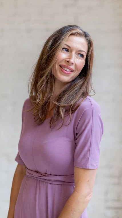 Load image into Gallery viewer, Woman wearing womens hospital gown, patient in lilac wrap dress style, close up of face, shoulder and top of dress