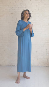 Woman wearing hospital patient gown cotton ocean blue Henley with a cup in her hand