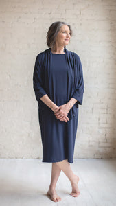 Woman wearing linen hospital patient gown in blue standing