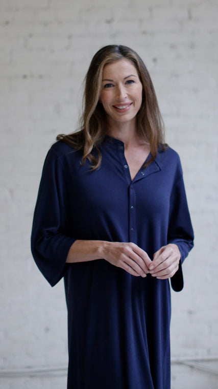 Woman wearing cotton hospital patient gown in dark blue Henley style front