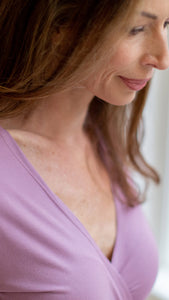 Woman in womens hospital gown wrap dress, modal lilac, closeup of neckline and face